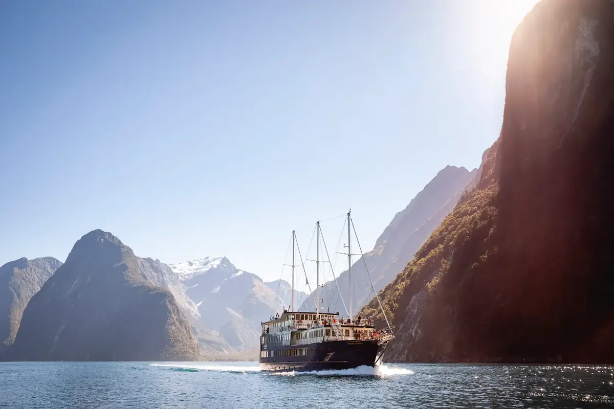 A cruise vessel beneath the sheer walls of Milford Sound